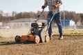 Man using aerator machine to scarification and aeration of lawn or meadow