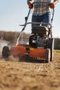 Man using aerator machine to scarification and aeration of lawn or meadow