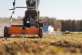 Man using aerator machine to scarification and aeration of lawn or meadow