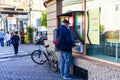 Man using an ATM in downtown of Lugoj, Romania, 2020