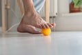 Man massaging arthritic feet with ball at home