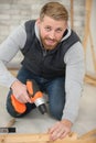 man using battery screwdriver to insert screw into wood Royalty Free Stock Photo