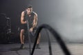 A Man Using Battle Ropes For Whipping Exercise in a Gym