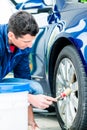 Man using brush for cleaning the surface of the rim Royalty Free Stock Photo