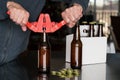 Man using capper to put metal caps on beer bottle