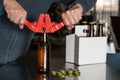 Man using capper to put metal caps on beer bottle