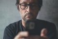 Man using cellphone at home, closeup shot of unkempt male with smartphone in hands