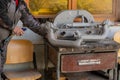 Man is using a compressed air pistol to clean out car parts from sand which were just sandblasted before restoration. Cleaning of