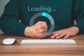 Man using a computer keyboard to download and waiting to loading digital business data form website. Royalty Free Stock Photo