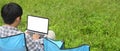 A man is using a computer laptop while sitting over the park. Royalty Free Stock Photo