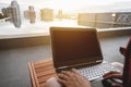 A man using computer laptop, on sunbathe lounge chair at swimming pool in the city, selective focus. Clipping path computer screen Royalty Free Stock Photo