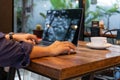 Man using computer mouse working on laptop at table in cafe. Royalty Free Stock Photo