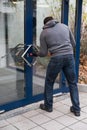 Man Using Crowbar To Open Glass Door Royalty Free Stock Photo