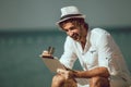 Man using digital tablet and credit card at sea beach Royalty Free Stock Photo