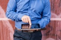 Man using digital tablet and leaning on wall outdoors