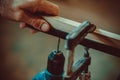 Man using the drill makes a hole in wood and iron strap. Royalty Free Stock Photo