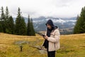 Man using drone controller in mountain meadow. Man in hooded jacket operating a drone controller in an open mountain field Royalty Free Stock Photo