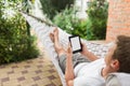 Man using e-book or tablet computer while relaxing in a hammock Royalty Free Stock Photo