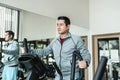 A man using elliptical trainer in fitness gym. Fitness, workout, sport and health concept