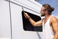 Man using a file to deburr a window opening in a camper van Royalty Free Stock Photo