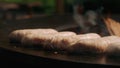 Man using forceps on grill outdoors. Man turning over sausages on grate