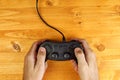 Man using game pad controller on wooden desk, top view Royalty Free Stock Photo