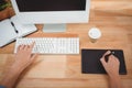 Man using graphics tablet while typing on keyboard Royalty Free Stock Photo