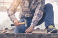 A young man using a hammer to nail concrete. Royalty Free Stock Photo