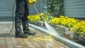 Man using high pressure washer to clean brick walkway Royalty Free Stock Photo