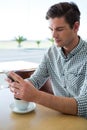 Man using his mobile phone in coffee shop Royalty Free Stock Photo