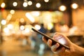 Man using his Mobile Phone in the pub or restaurant, night light. Royalty Free Stock Photo