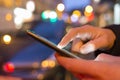 Man using his Mobile Phone in the street, night light bokeh Back Royalty Free Stock Photo