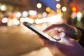 Man using his Mobile Phone in the street, night light bokeh Royalty Free Stock Photo