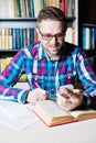 Man using his mobile smart phone , book on wooden table. Royalty Free Stock Photo