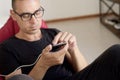 Man using his smartphone sitting in bean bag chair Royalty Free Stock Photo