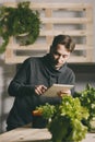 Man using his tablet while growing plants