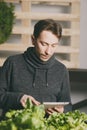 Man using his tablet while growing plants