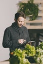 Man using his tablet while growing plants