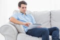 Man using his tablet sitting on a couch Royalty Free Stock Photo
