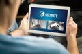 Man using home security system and application in tablet. Royalty Free Stock Photo