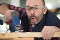 man using jigsaw blowing sawdust from wood Royalty Free Stock Photo