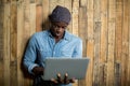 Man using laptop against wooden wall Royalty Free Stock Photo