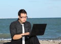 man using laptop at beach Royalty Free Stock Photo