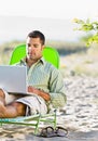 Man using laptop at beach Royalty Free Stock Photo