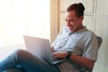 Man using laptop computer while sitting in living room Royalty Free Stock Photo