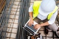 Man using laptop on construction site. Building industry details