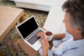 Man using laptop while having coffee in living room Royalty Free Stock Photo