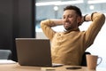 Man Using Laptop Holding Hands Behind Head Resting In Office Royalty Free Stock Photo