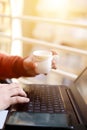 Man is using laptop with holding tea cup in hand Royalty Free Stock Photo