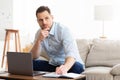 Man using laptop at home and writing notes in notepad Royalty Free Stock Photo